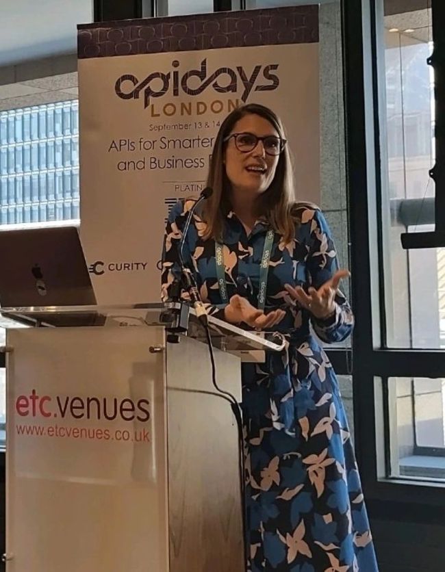 Kayleigh speaking at a lectern at apidays London