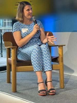 Kayleigh speaking on a panel, holding a microphone